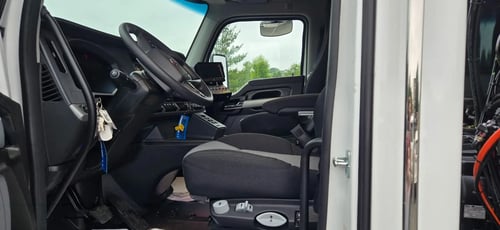 Driver side cab interior with controls and seating in 2026 TRUVAC HXX hydro excavation truck